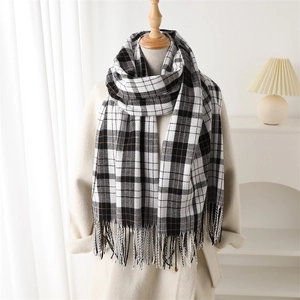 Classic black and white plaid cashmere-like scarf with tassels on a coat display