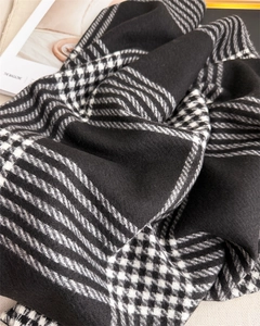 Detail of classic black and white houndstooth cashmere scarf with soft knitted texture