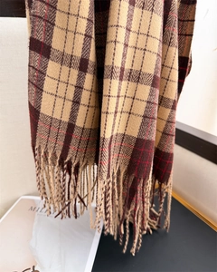 Detailed texture of thick plaid scarf with classic fringe and soft cashmere feel
