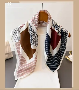 Detailed texture of geometric pattern scarf with silk-like finish on a hanger