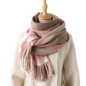Pink and brown plaid cashmere-like winter scarf with fringe displayed on a mannequin