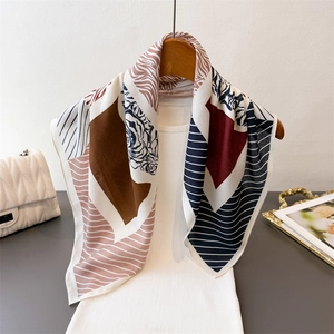 Elegant geometric mixed pattern silk scarf on white top with premium lifestyle props