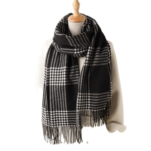 Classic black and white checkered plaid tassel scarf on a mannequin over a beige coat