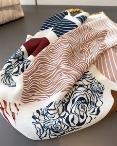 Detail of color-block scarf with rose and zebra prints featuring a gold metal hook