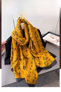 Close-up of ginger silk scarf with black calligraphy print and soft drape detail