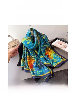 Detail of royal blue silk scarf with yellow abstract print draped over a black suit