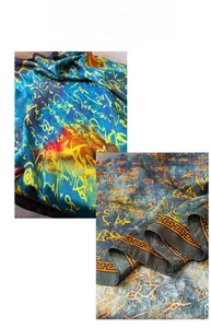 Detail of silk scarf featuring calligraphic prints and geometric patterns on luxury fabric