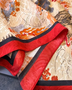 Detailed close-up of premium silk scarf featuring traditional dragon and floral patterns