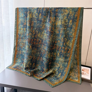 Close-up of silk scarf showing golden oracle script patterns and classical borders