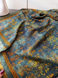 Close-up of silk scarf showing vintage hieroglyphic prints and orange fretwork borders