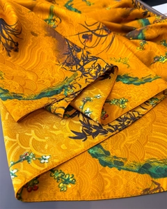 Detail of silk scarf showing golden jacquard texture and bamboo floral print