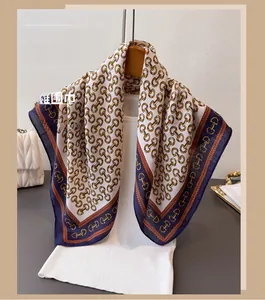Detailed view of luxury satin square scarf featuring vintage gold horsebit chain patterns