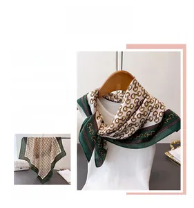 Detail view of vintage emerald green silk scarf with golden horsebit chain patterns