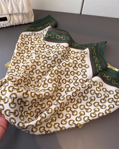 Detail of silk-feel scarf with horsebit chain print and vintage equestrian green border
