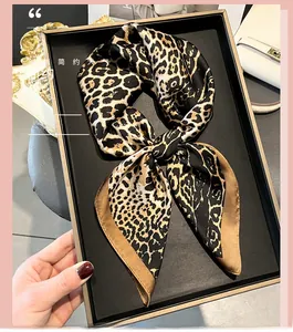 Detailed view of leopard print silk scarf with satin finish and golden yellow border