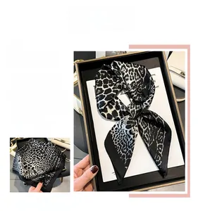 Close-up of leopard print silk scarf in black and white satin fabric with elegant drape