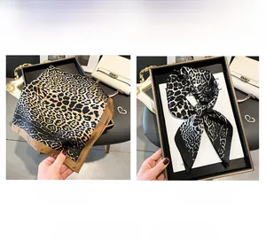 Detail view of leopard print silk scarf in coffee and black colors on display tray
