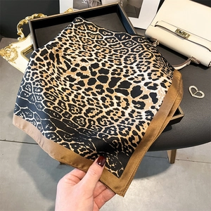 Square leopard print silk scarf with satin edges styled with elegant accessories