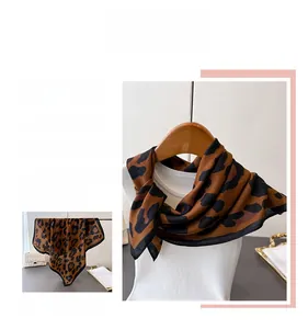 Detail view of leopard print silk scarf texture and elegant hem stitching on model