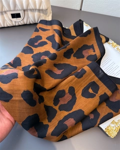 Detail view of leopard print cotton scarf featuring fine herringbone texture and black border