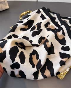 Macro shot of leopard print scarf with herringbone weave and elegant black border trim