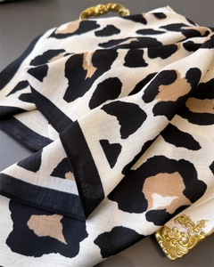Detail shot of leopard print scarf featuring herringbone texture and black border finish