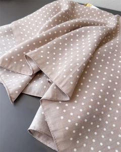 Detailopname van de bruine polkadot sjaal met fijne visgraatweefsel textuur