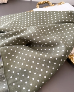 Detailweergave van olijfgroene visgraatsjaal met witte stippen en zachte textuur