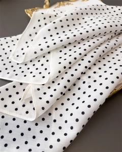 Detailopname van vintage zwart-witte polkadot zijden sjaal met fijne rolzoom afwerking
