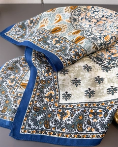 Detail of floral paisley pattern on silk scarf with elegant navy border and twill texture