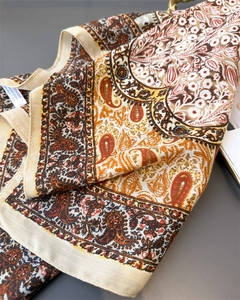 Detail of warm-toned paisley floral pattern on soft velvet feel cotton linen scarf