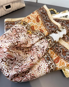 Detail of vintage paisley floral silk scarf with rich brown and orange patchwork texture