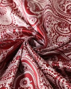 Gros plan détaillé du tissu satiné à motif cachemire avec texture soie bordeaux et crème