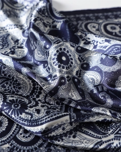 Gros plan détaillé sur un tissu satiné à motif cachemire bleu et reflets soyeux