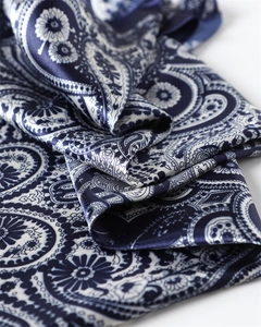 Gros plan d'un foulard en satin à motif paisley élégant avec des fleurs bleues et blanches