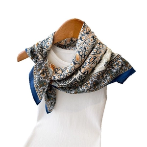 Elegant navy paisley floral silk scarf styled on a white tank top for women