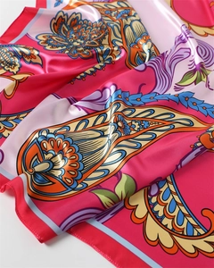 Dettaglio macro del foulard di seta satinata con stampa paisley in rosa vivace