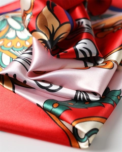 Dettaglio macro di un foulard di seta satinata con stampa paisley floreale rossa e arancione