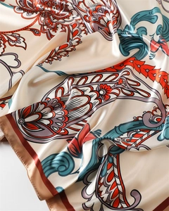 Dettaglio della sciarpa in raso paisley con motivi floreali e lucentezza setosa elegante