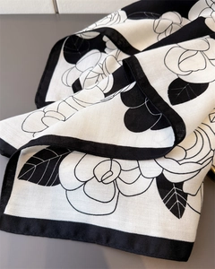 Detail of herringbone texture and white camellia pattern on black and white scarf
