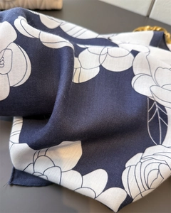 Detailed close-up of navy blue scarf with white camellia flower patterns on twill fabric