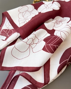 Macro detail of red and white floral scarf showing fine herringbone texture and stitching