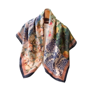 Double-sided herringbone silk scarf with floral and baroque patterns on a wooden hanger