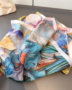 Detail of floral silk scarf with golden outlines on vintage golden tray background