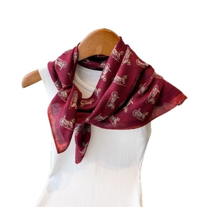 Double-sided burgundy silk scarf with classic carriage print on a white mannequin