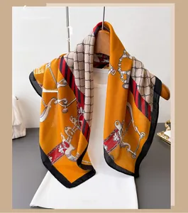 Detail of harness chain pattern on orange silk scarf draped over a white vest