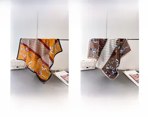 Detail view of cotton-linen scarves with equestrian chain patterns in orange and coffee tones