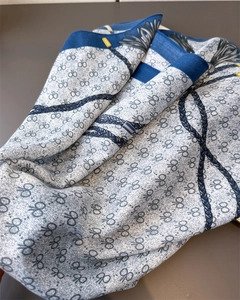 Détail du foulard luxueux en soie avec motifs de chaînes bleues et de glands élégants