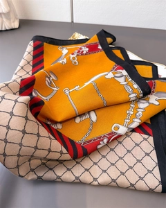 Detailed close-up of equestrian chain and stirrup patterns on a silk-like square scarf