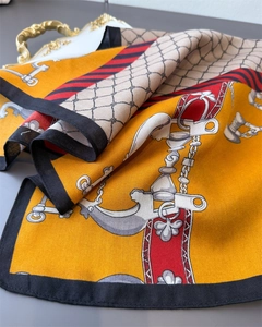 Macro shot of orange horse harness chain silk scarf with elegant herringbone texture